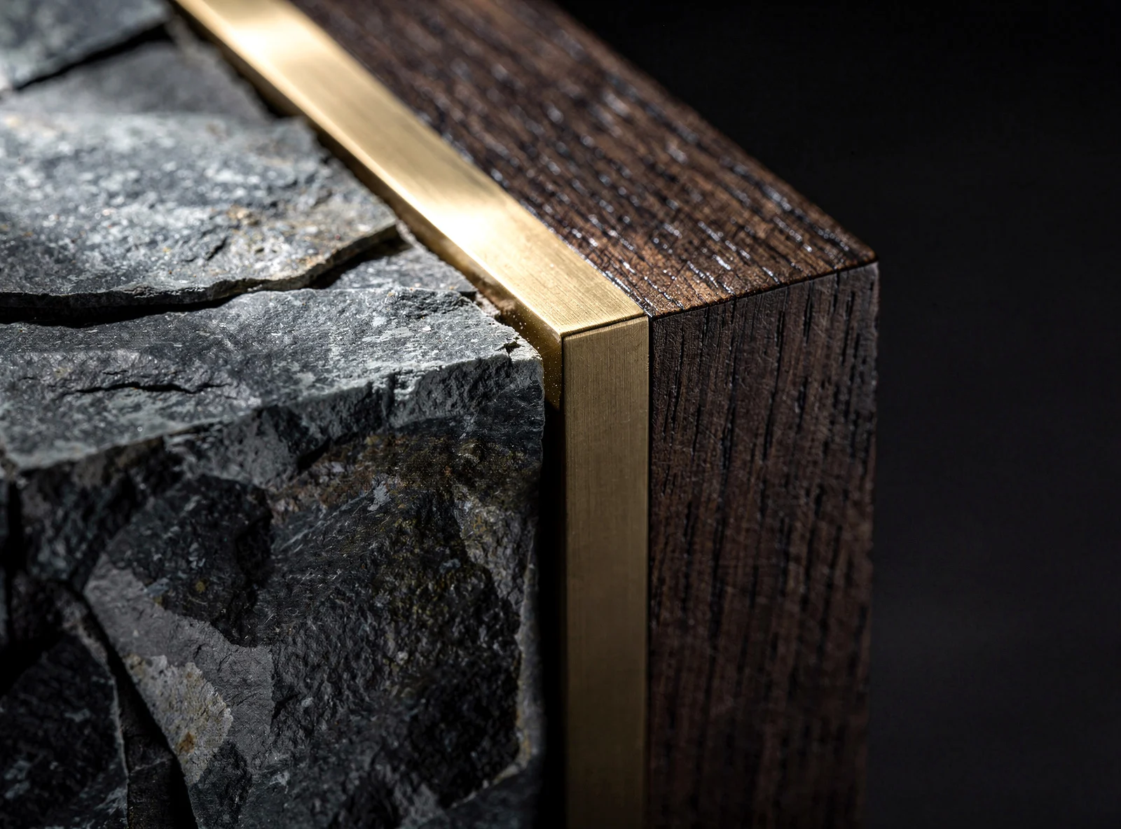 A material detail — stone, oak and brass in precise combination